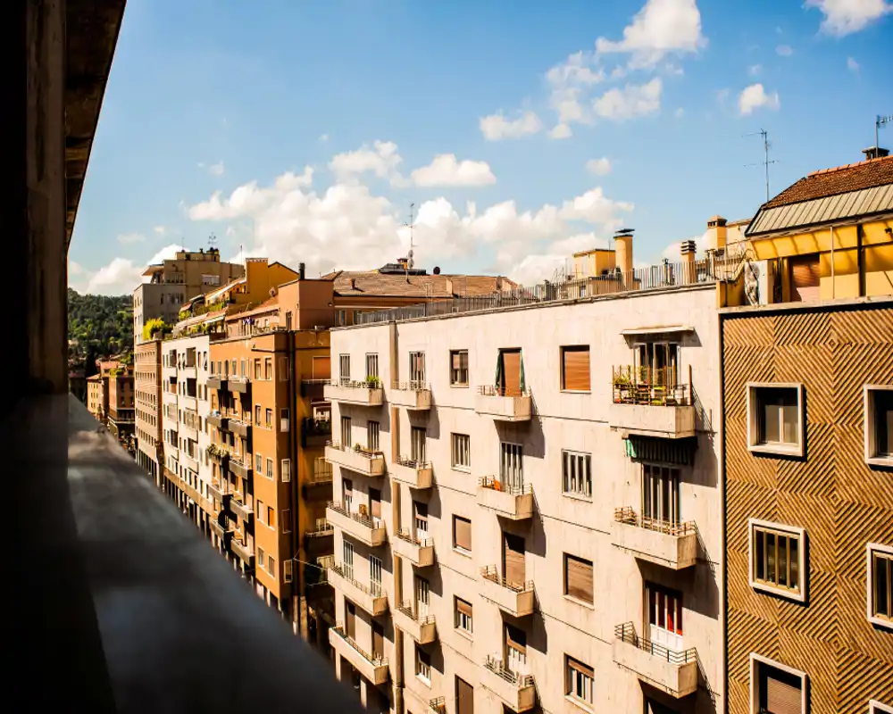 Sunny balcony view overlooking classic city apartment facades, ideal for showcasing outdoor space and neighborhood ambiance.