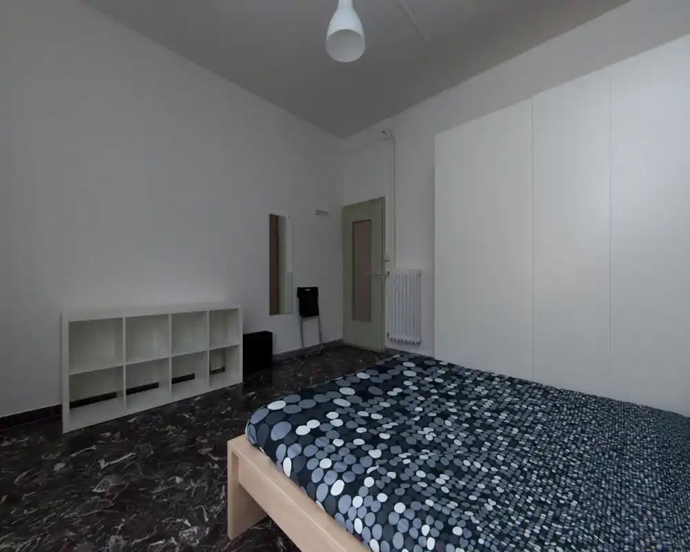 Chambre minimaliste avec lit double et couette à motifs, grand placard blanc, étagères ouvertes et sol effet marbre; tons neutres et agencement soigné pour une ambiance calme.