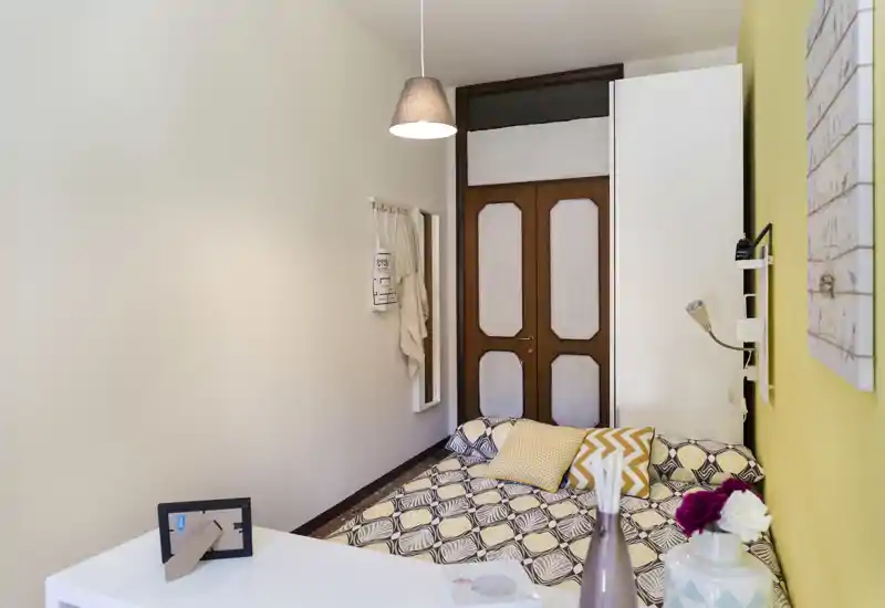 Bright, well-staged single bedroom with patterned bedding, decorative cushions and a pendant light—suitable for a cozy rental listing.