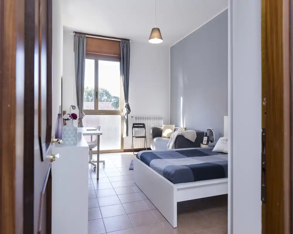 Chambre lumineuse et moderne avec un lit double, des textiles confortables et une fenêtre apportant une belle lumière naturelle. Tons neutres et mobilier épuré pour une ambiance apaisante, parfaite pour une annonce locative.