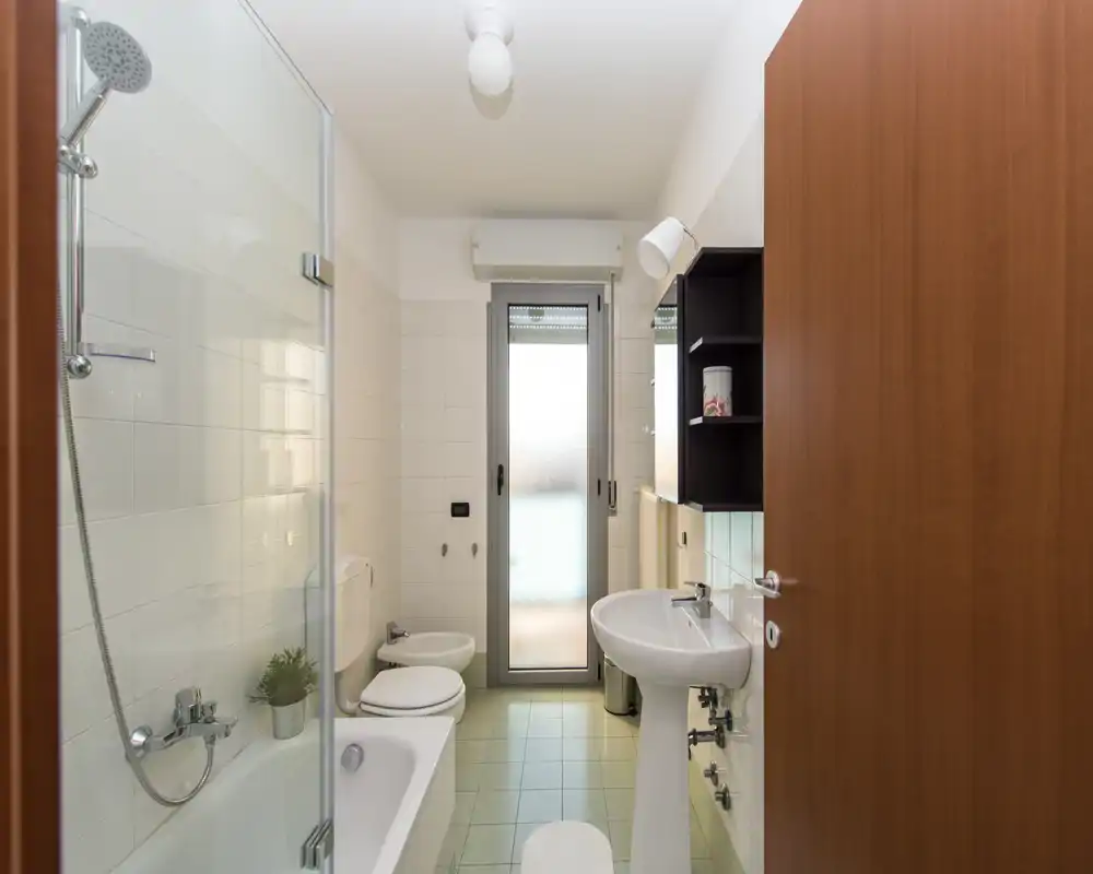 Baño luminoso y bien cuidado con combinación bañera/ducha, bidé y lavabo; puerta de vidrio esmerilado que aporta privacidad y luz natural.