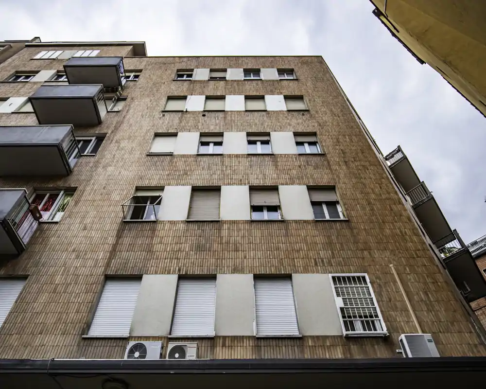 Vista esterna di un edificio residenziale multipiano con facciata in mattoni, varie finestre e piccoli balconi; adatta a mostrare l’aspetto esterno e l’appeal della via.