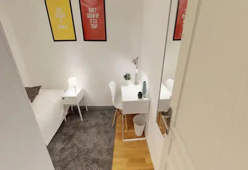 Camera da letto singola luminosa e accogliente con letto bianco, comodino e piccolo scrittoio. Arredo minimale contemporaneo, tappeto morbido e quadri alle pareti la rendono ideale per soggiorni brevi o lunghi.