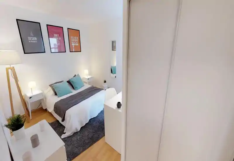 Bright, well-staged bedroom with a double bed, soft pillows and coordinated textiles, bedside tables and ambient lamps offering a cozy atmosphere.