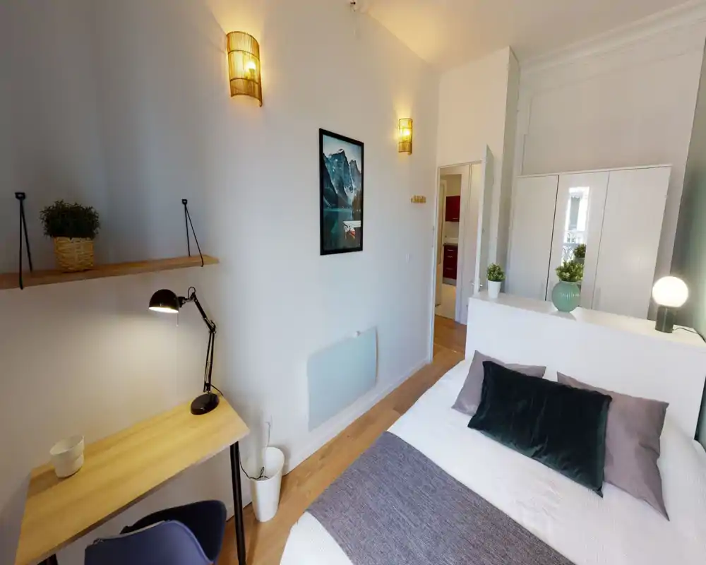 Bright, well-styled bedroom with a double bed, decorative cushions, plants and a small workspace—ideal for a comfortable stay.