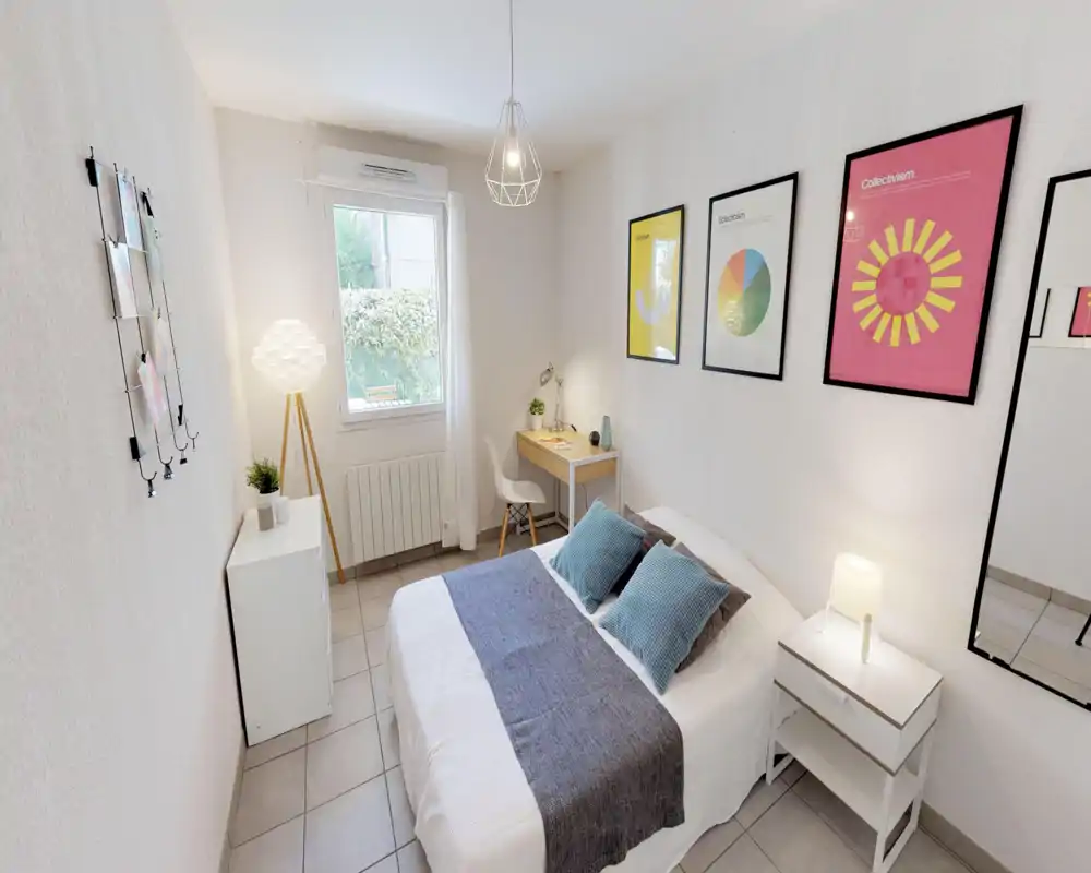 Bright, well-styled bedroom with a central double bed, bedside table and a small desk by the window — ideal for restful stays and light work.