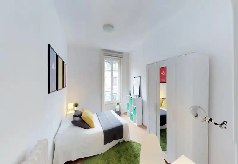 Bright, neatly staged bedroom with a double bed, cozy textiles and modern storage. Large window provides natural light and a fresh, airy atmosphere — ideal for listing photos.