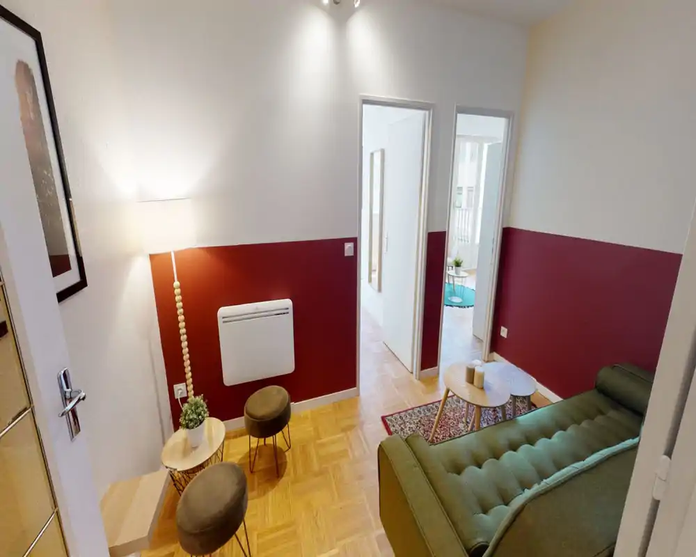 Soggiorno accogliente e ben arredato con divano verde, tavolini, lampada da terra calda e dettagli curati — ambiente luminoso e invitante per il relax.