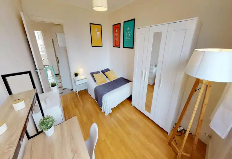 Bright, neatly staged bedroom with a double bed, bedside tables and a wardrobe. Clean wood flooring, framed prints and soft textiles create a cozy, welcoming atmosphere ideal for rental photos.