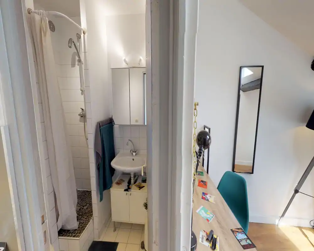 Bagno compatto con doccia piastrellata, lavabo bianco e mobiletto specchiato — pulito, ben illuminato e funzionale per soggiorni brevi.