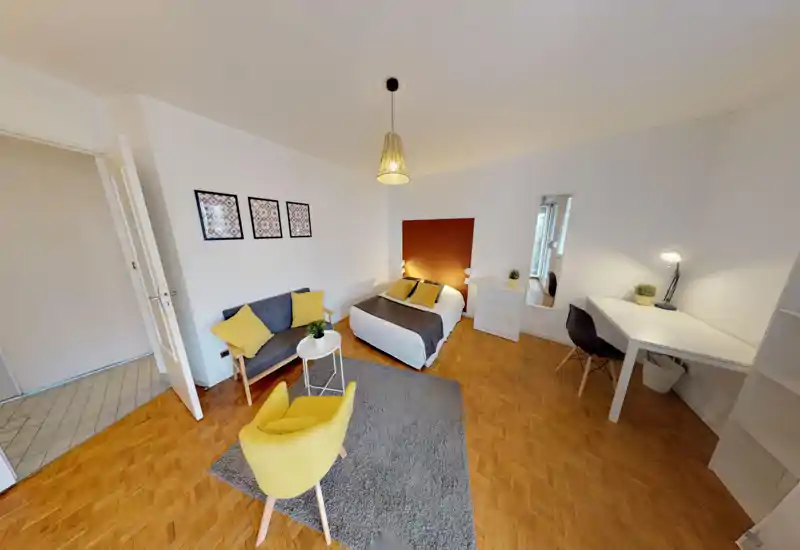 Spacious, well-styled bedroom with a double bed, cozy textiles and a seating area. Bright, harmonious decor with a desk and storage — ideal for long stays or remote work.