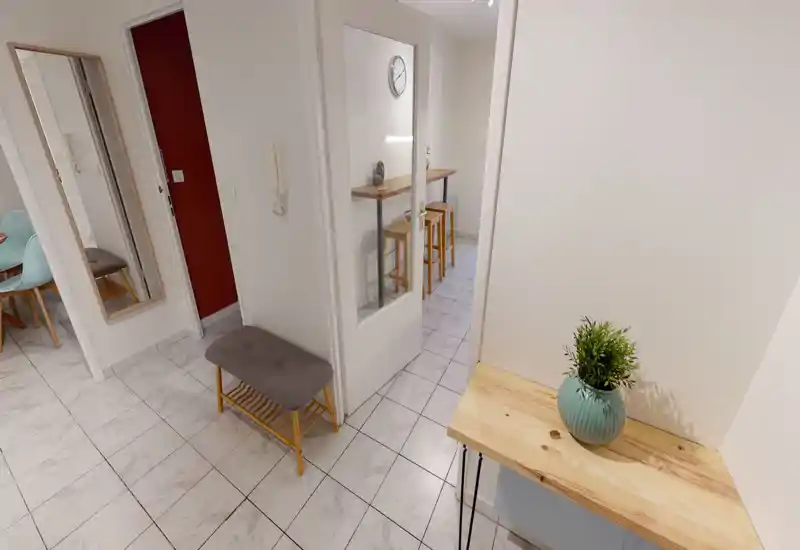 Entrée lumineuse et rangée avec sol carrelé, miroir, banc avec range-chaussures et petite console en bois avec plante décorative — belle première impression.