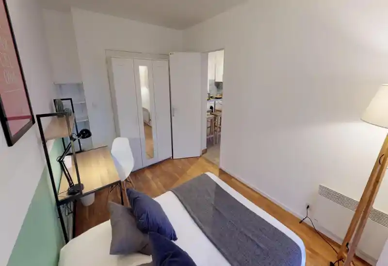 Bright, well-staged bedroom with a large bed, cozy textiles and a functional desk area — ideal for work and rest.