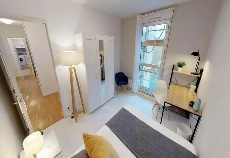 Bright, well-staged bedroom with a comfortable bed, desk by the window and a wardrobe — ideal for students or professionals seeking a compact, functional room.