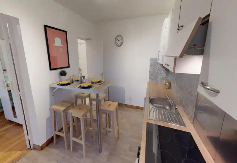 Well-equipped open kitchen with a wooden countertop, integrated sink and hob, and a high dining bar with stools set for four. Bright, neat space with patterned backsplash and contemporary white cabinets.