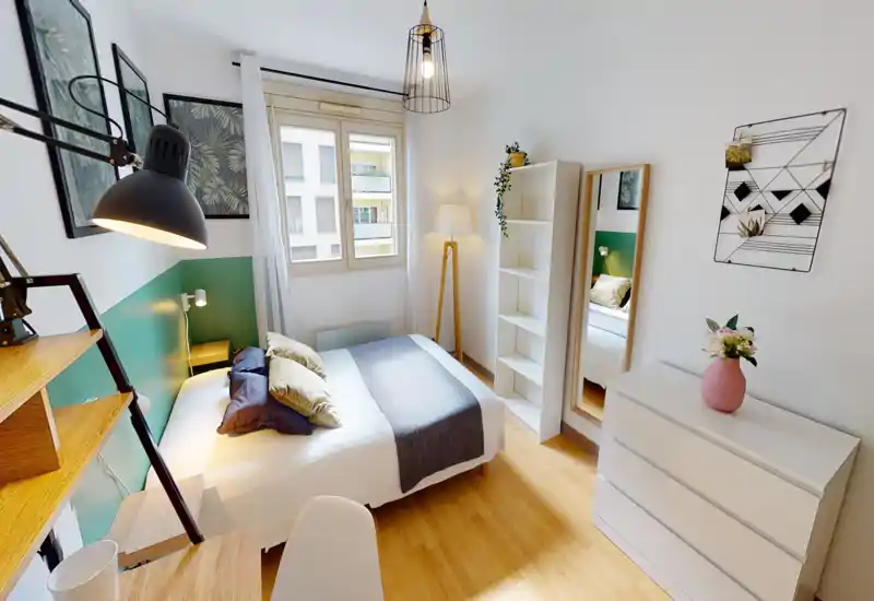 Bright, well-staged bedroom with a centrally placed double bed, bedside lamp, shelving and a tall mirror. Natural light from the window and tasteful decor create a cozy atmosphere ideal for rental photos.