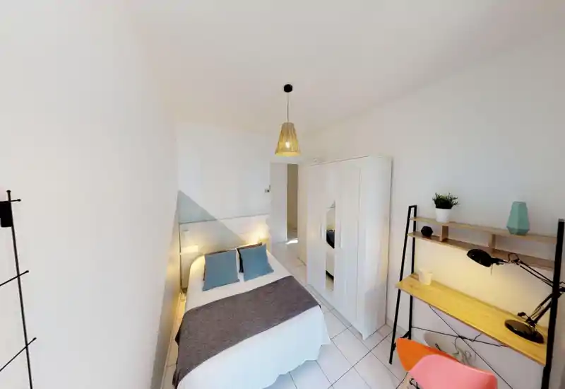 Bright, well-styled bedroom with a double bed, bedside lights, wardrobe and a small desk — ideal for comfortable short-term stays.