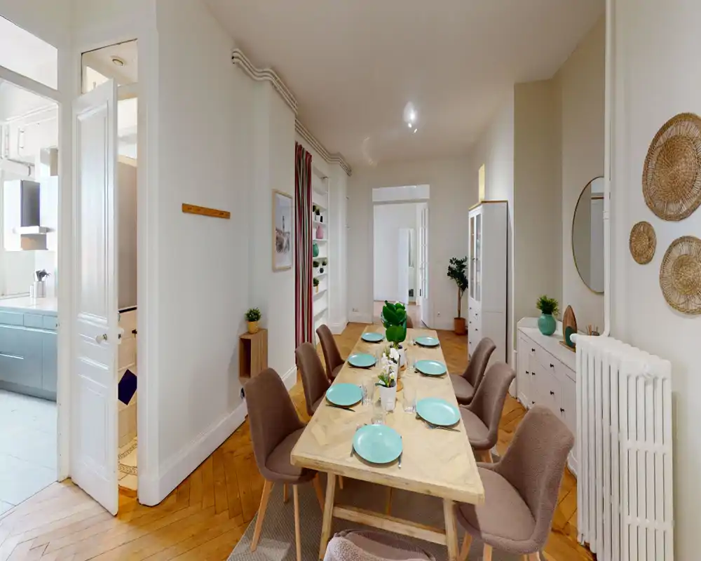 Ampia e elegante sala da pranzo con un grande tavolo in legno per otto persone, comode sedie imbottite e pavimento in parquet caldo — perfetta per pranzi e riunioni.