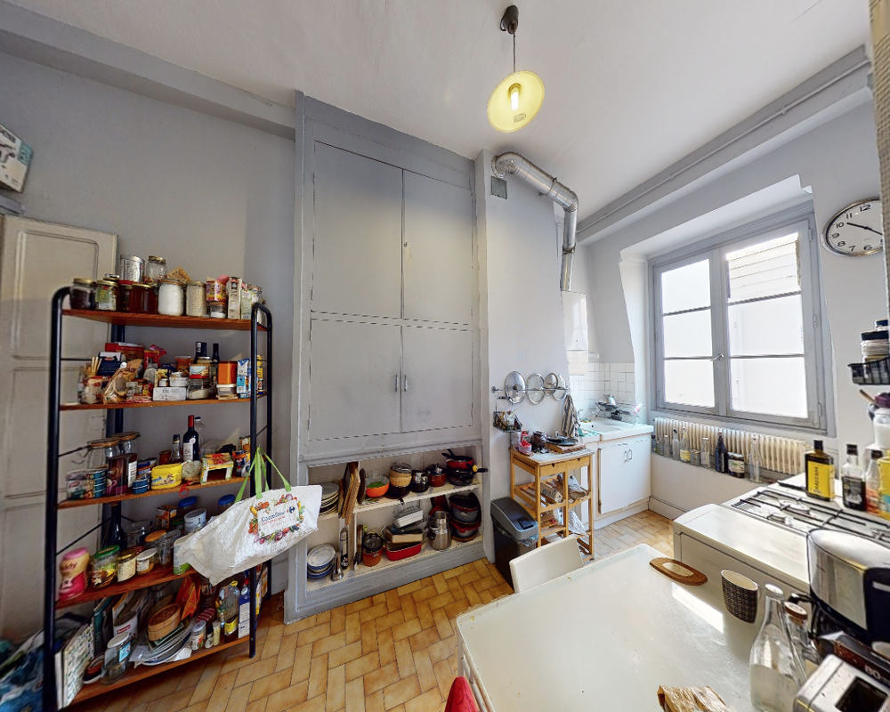 Cocina luminosa y vivida con estanterías abiertas, cocina de gas y una ventana que aporta luz natural. Estanterías bien surtidas y menaje que transmiten una sensación acogedora y funcional.