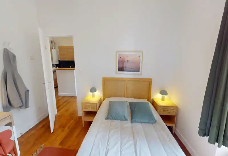 Camera da letto luminosa e ordinata con letto matrimoniale centrale, comodini coordinati e lampade calde; arredo semplice e luce naturale creano un ambiente accogliente.