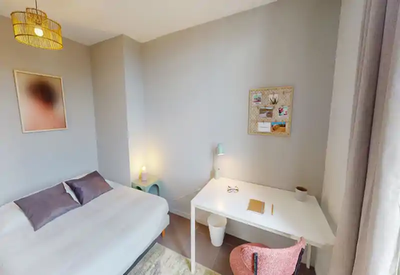 Bright, neatly styled bedroom with a double bed, bedside lighting and a small desk by the window — ideal for rest and light work.