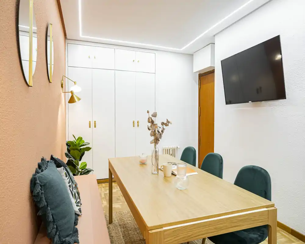 Stylish dining area with a wooden table, comfortable upholstered chairs and warm accent wall—ideal for meals or remote work.