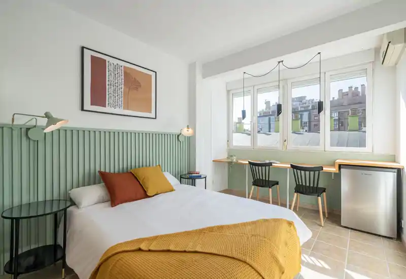 Bright, well-staged bedroom with a large bed, soft textiles and a window providing natural light — ideal for rental photos.