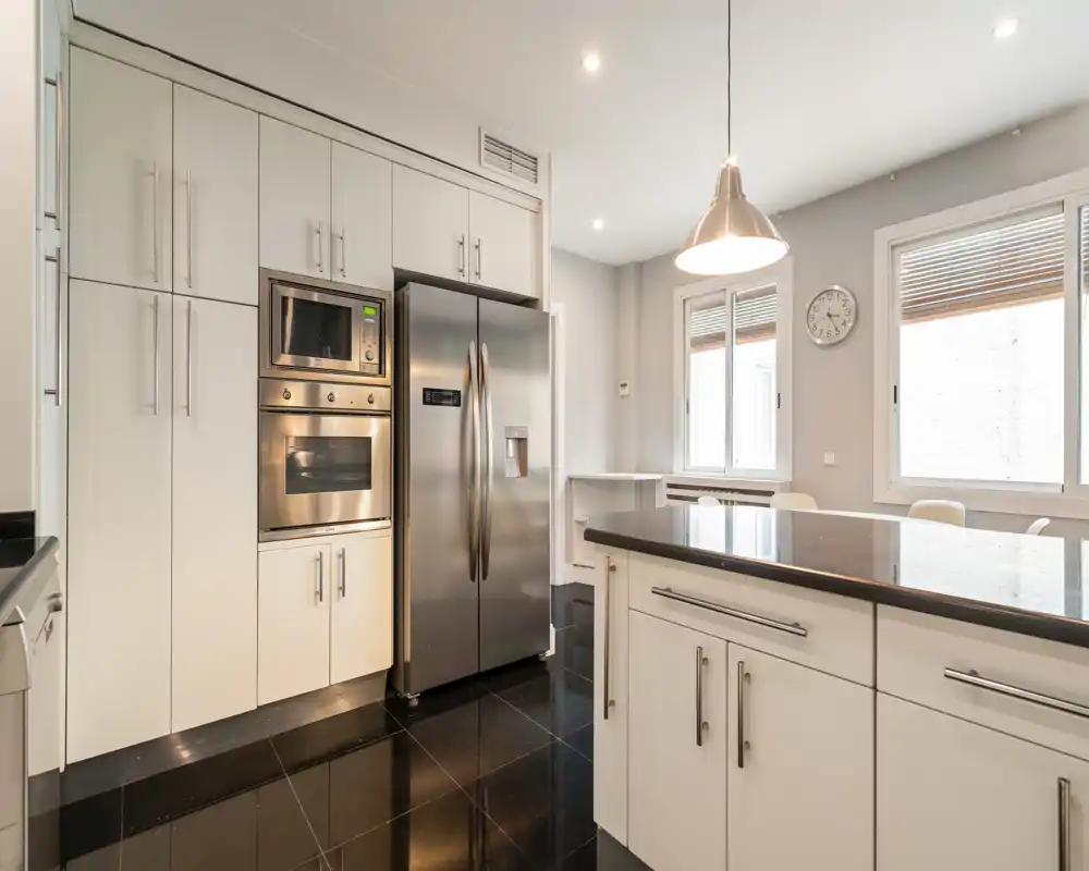 Bright modern kitchen with a central island, stainless-steel appliances and abundant cabinet storage — clean, contemporary space ideal for cooking and entertaining.