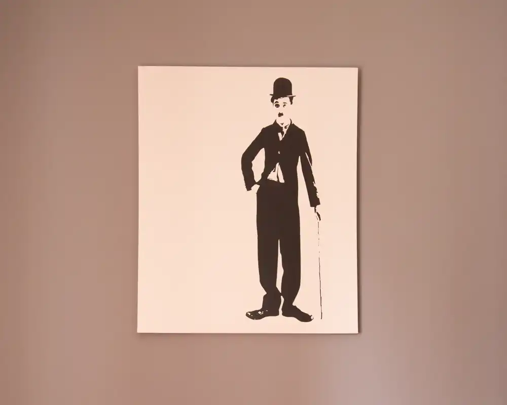 Quadro in bianco e nero con figura in stile vintage appeso su una parete tinta unita; l'immagine mostra soprattutto l'opera d'arte e non elementi distintivi di una stanza.