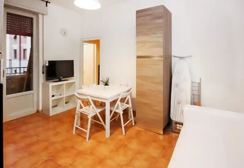 Espace de vie lumineux et soigné avec une petite table, un meuble TV et un canapé compact — parfait pour un appartement urbain chaleureux.