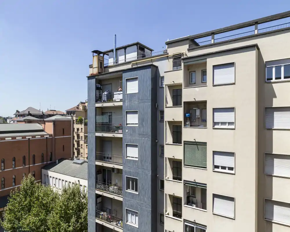 Vista esterna di edifici residenziali con diversi balconi e cielo azzurro; utile per mostrare la facciata e il contesto urbano circostante.