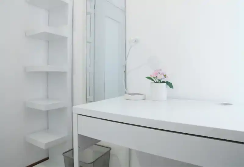 Rincón de escritorio minimalista y luminoso en blanco con lámpara y planta en maceta; espacio de trabajo/toallero de estilo escandinavo limpio.