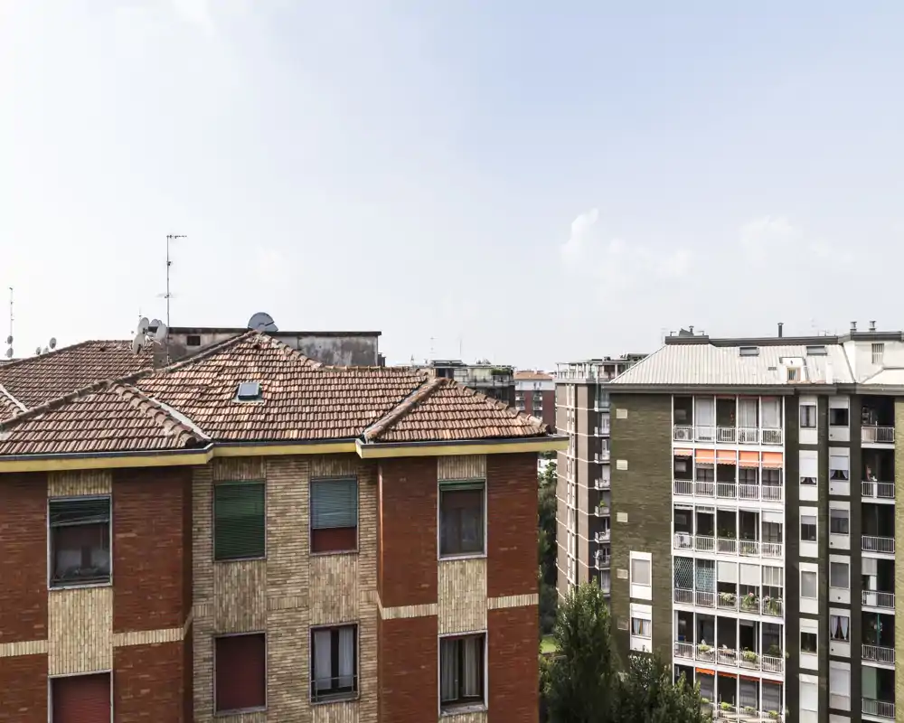 Urban exterior view showing neighboring apartment buildings and rooftops, suitable as a listing photo for a balcony or window view.