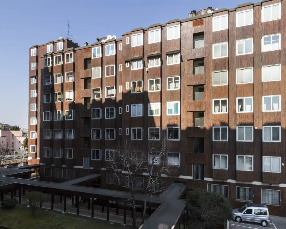 Vista esterna di un edificio residenziale con cortile e pensilina, molte finestre di appartamenti visibili alla luce del giorno.