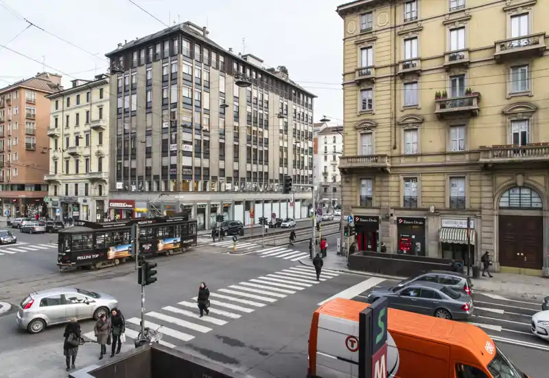 Urban street intersection with tram, pedestrians and surrounding buildings — a clear view of city transport and street life.
