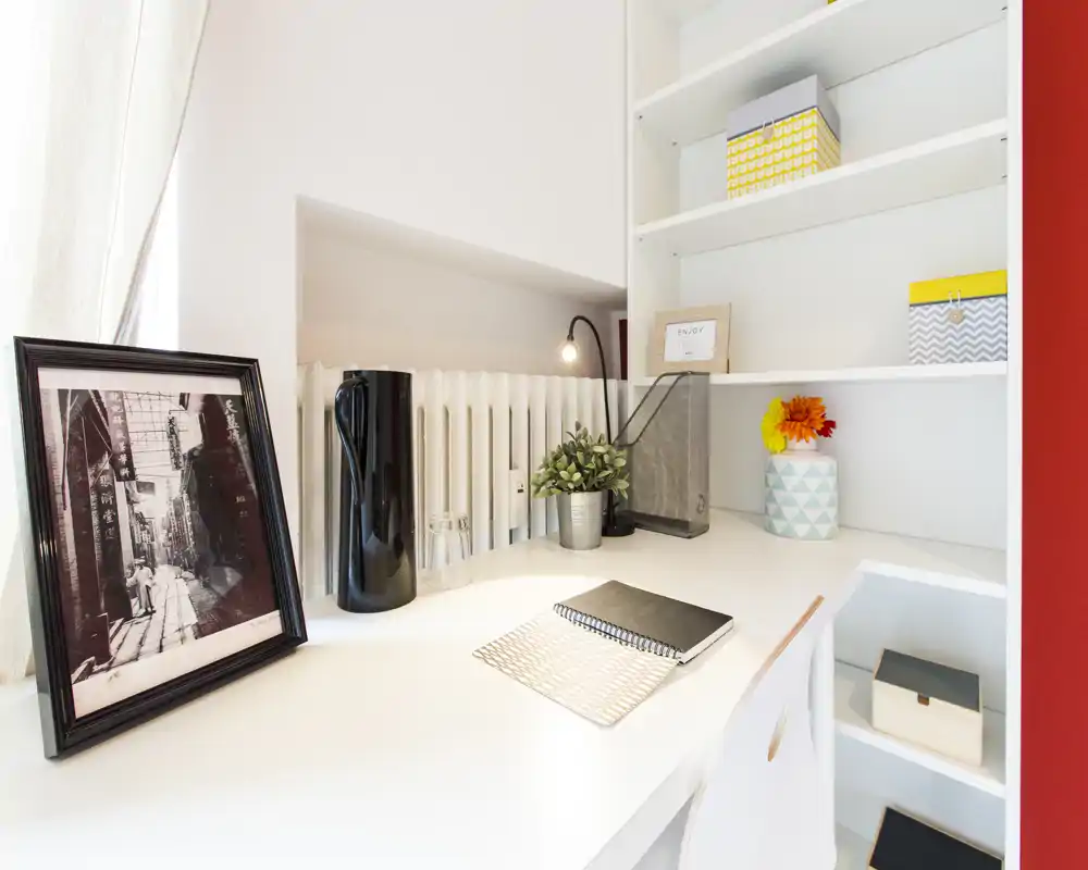 Bright, tidy desk corner with shelving and decorative items — a cozy home-office or study nook ideal for focused work.