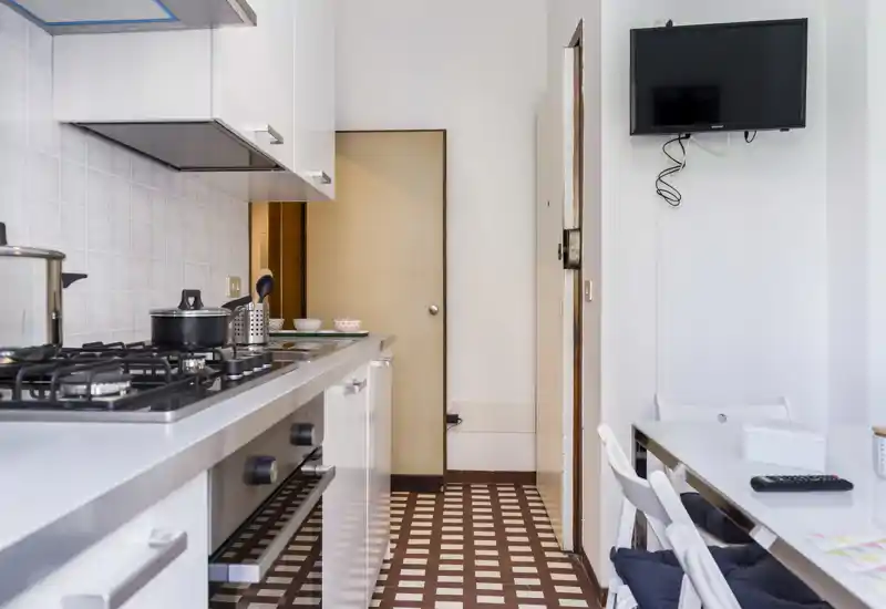 Bright, modern kitchenette with a gas hob, countertop appliances and a small dining area — clean, functional space ideal for short stays.