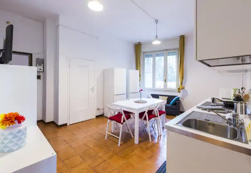 Cocina luminosa y bien equipada con mesa para cuatro, electrodomésticos modernos y un rincón acogedor junto a la ventana.