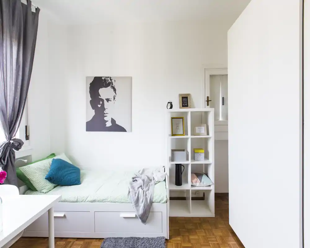 Dormitorio individual luminoso y bien decorado con cama tipo daybed, ropa de cama suave y cuadro decorativo — perfecto para una estancia acogedora.