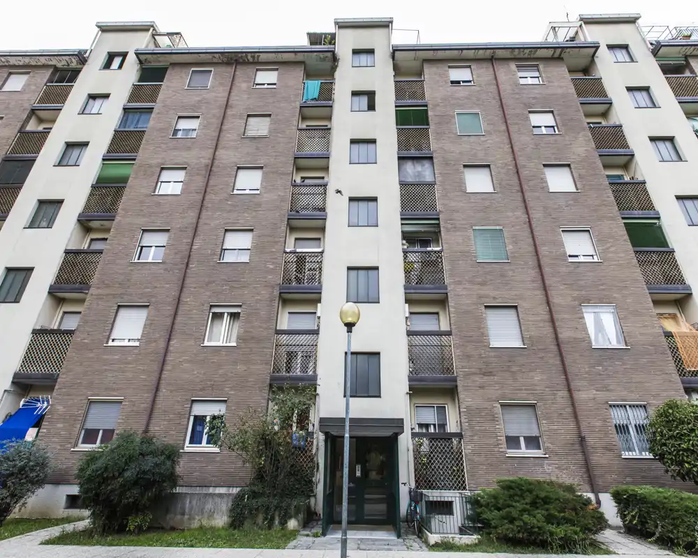 Vue extérieure d'un immeuble résidentiel multi-étages avec balcons et entrée — adaptée pour présenter la façade et l'emplacement du bâtiment.