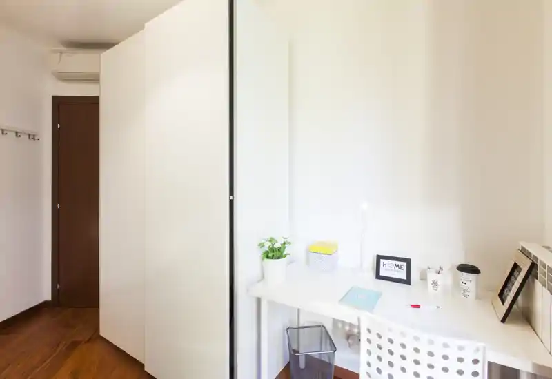 Bright, minimal workspace corner with a white desk, chair and decorative accents — suitable for a compact home office or study area.
