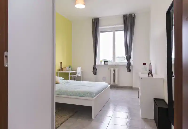 Bright, neatly styled bedroom with a visible double bed, bedside furniture and natural light from a window — ideal for rental listings highlighting comfort and cleanliness.