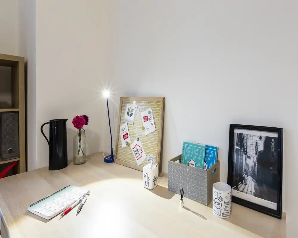 Bright, tidy workspace corner with a desk lamp, decorative objects, and organized stationery — ideal for focused work or study.