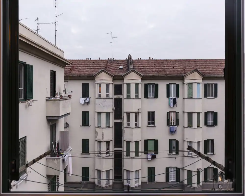 Vista dalla finestra su edifici e balconi del palazzo di fronte; utile per mostrare l’affaccio esterno e l’esposizione alla luce.