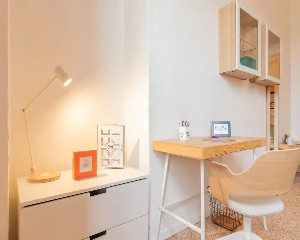 Coin bureau lumineux et soigné avec un bureau en bois, chaise confortable, lampe et petites décorations — idéal pour travailler au calme.