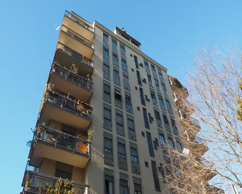 Exterior view of an apartment building with multiple balconies, captured in clear daylight. Ideal for listing the building facade and balcony features.