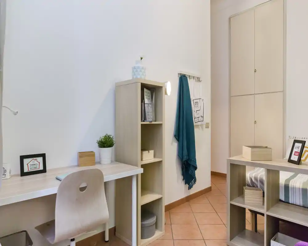 Dormitorio luminoso y bien decorado, con vista parcial de la cama, escritorio y estanterías — ideal para ocupación individual o estudiantes.