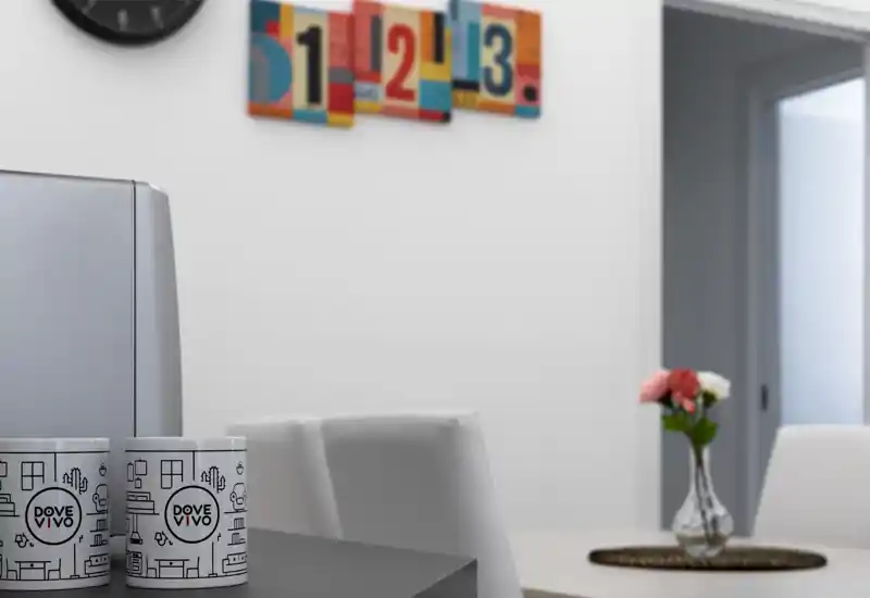 Zona pranzo moderna e luminosa con un piccolo tavolo, vaso con fiori e arte murale contemporanea — stile pulito ideale per annunci.