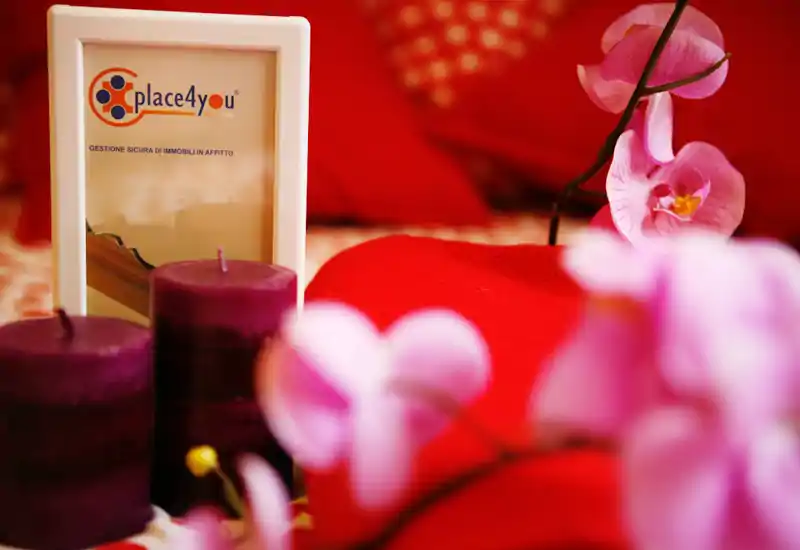 Plano detalle de dormitorio con textiles suaves, velas decorativas y orquídeas que crean una atmósfera cálida e íntima; perfecto como imagen detallada para un anuncio.