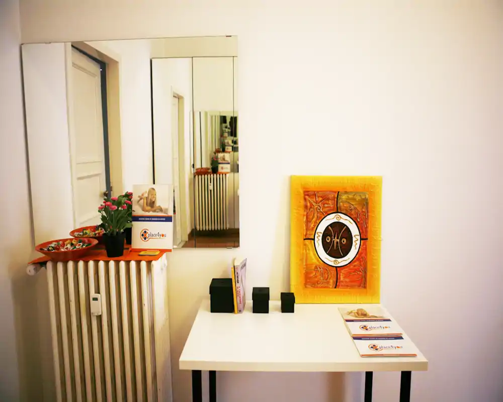 Entrada ordenada o pequeño recibidor con mesa, obra decorativa, espejo y radiador; espacio luminoso, minimalista y acogedor, ideal para un vestíbulo.